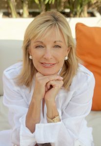 Picture of Susie Ellis, GWS founder, wearing a white shirt and with her chin resting on her hands
