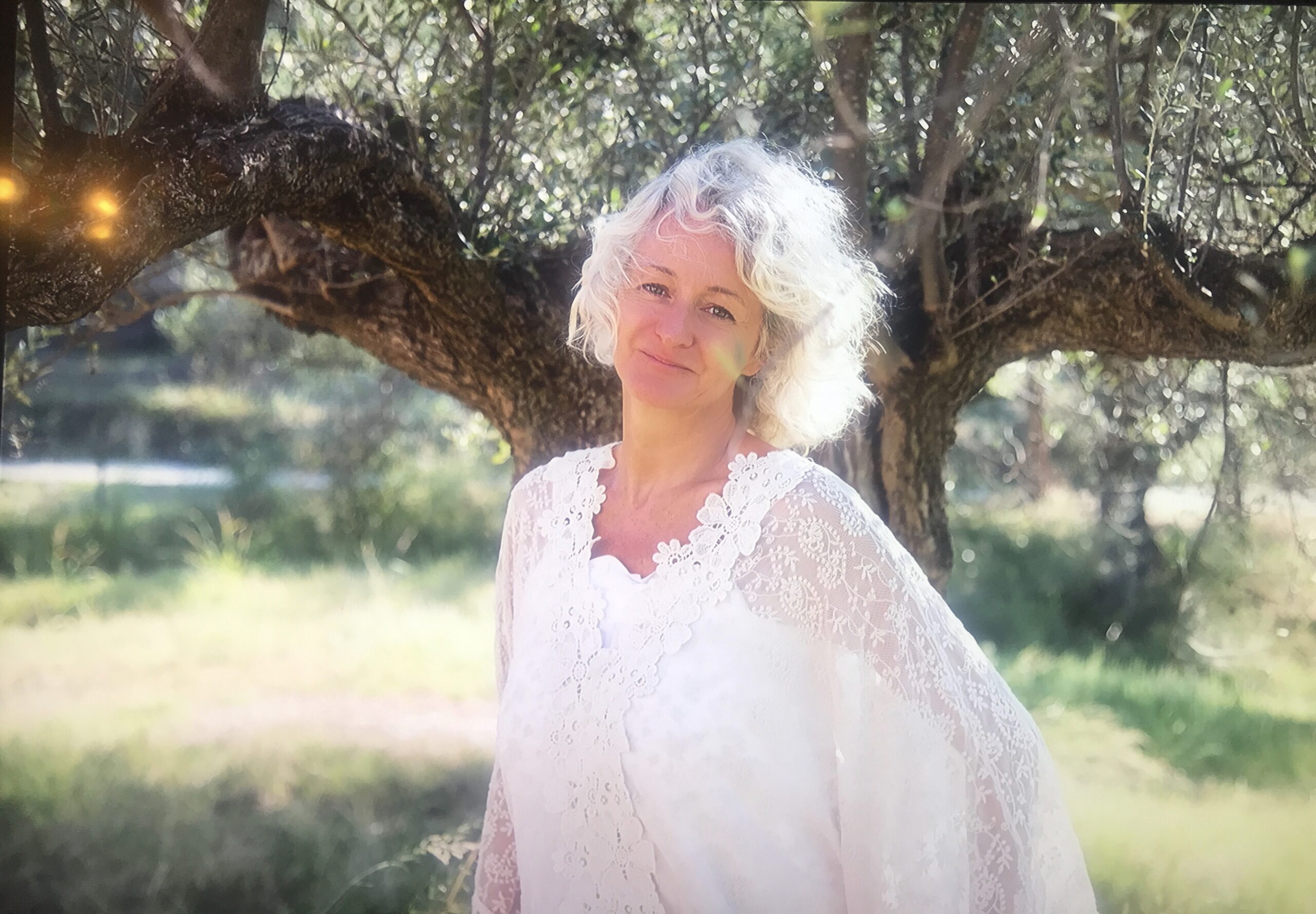Picture of Patrizia Bortolin in a white flowing top on a sunny day with a large tree in the background