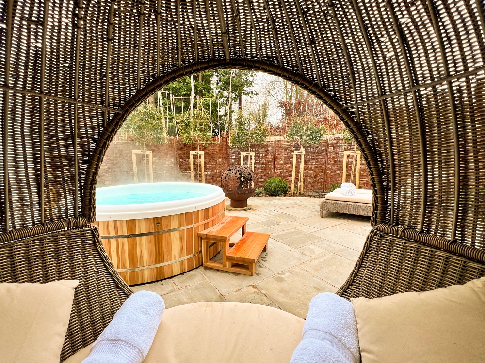 A shot of an outdoor jacuzzi from a woven relaxation pod