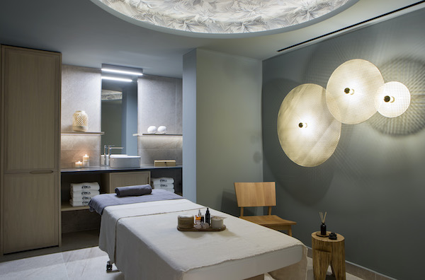 spa treatment room featuring a modern treatment bed and mood lighting on the wall