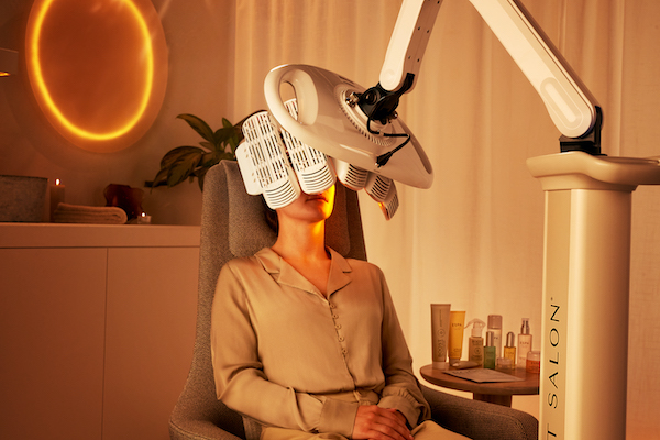 woman having an LED red light therapy facial seated in a chair