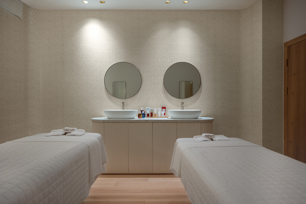 A spa treatment room with two beds