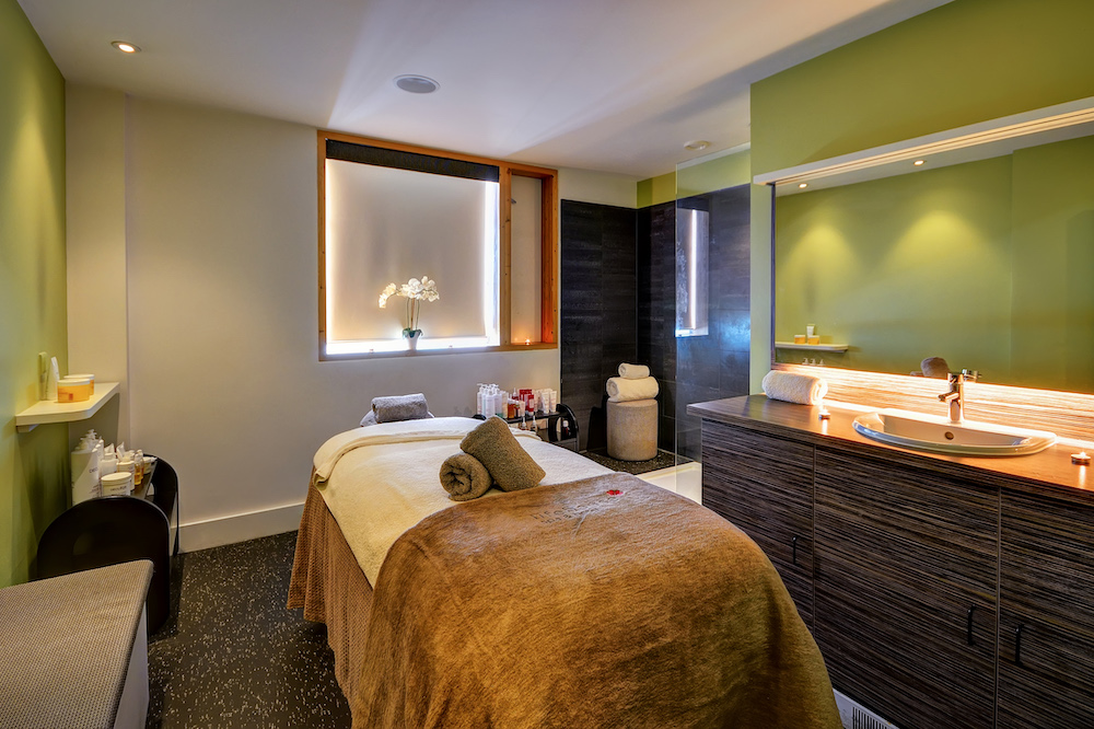 A spa treatment room with green walls