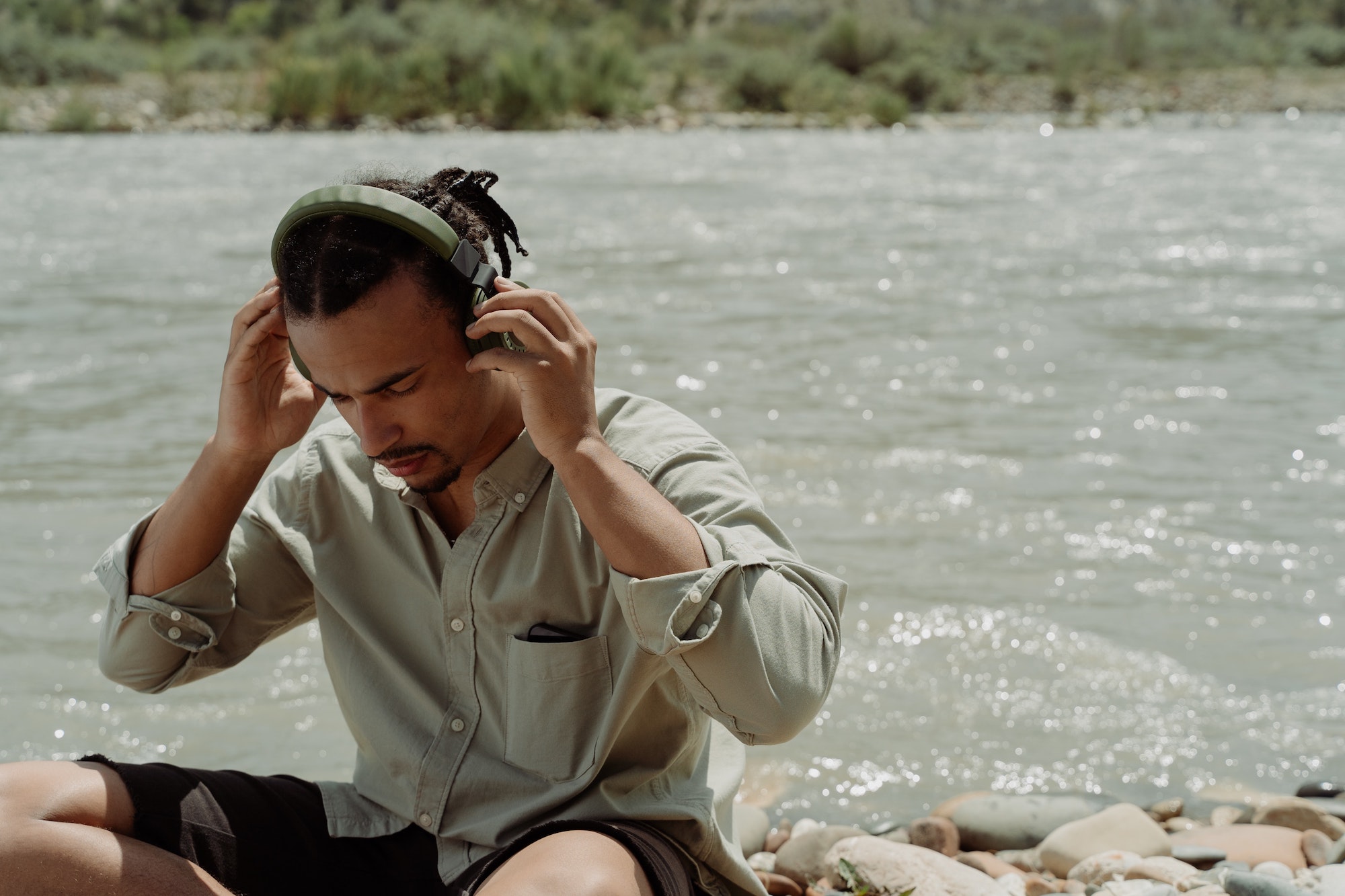 man in headphones sat by water
