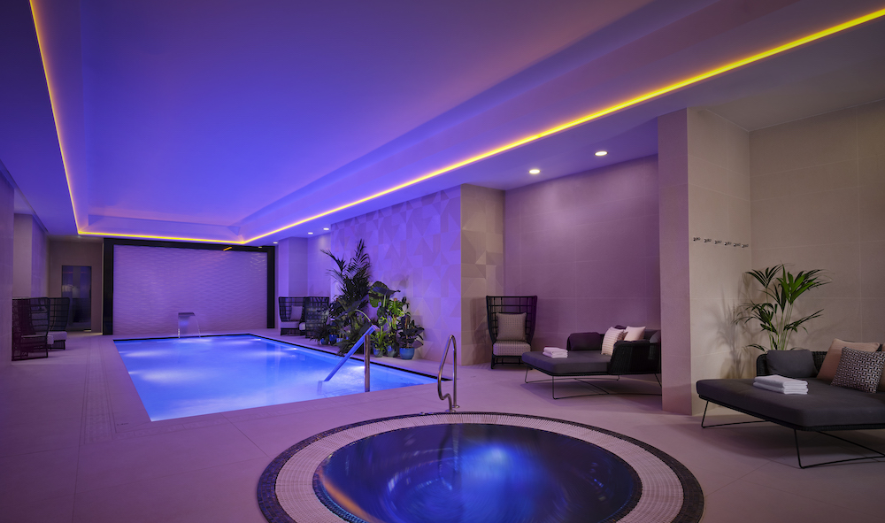A hotel swimming pool and spa pool with blue lighting