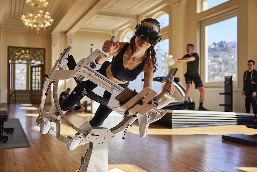 Woman suspended on exercise machine in VR headset