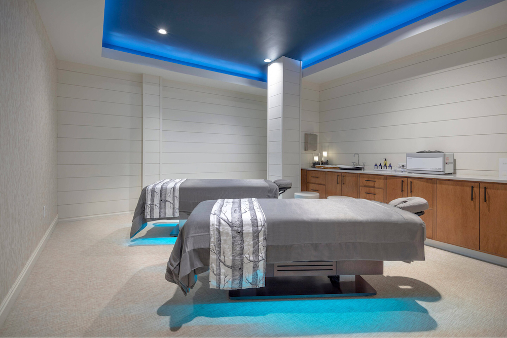Two tearment beds in a spa treatment room with blue lighting