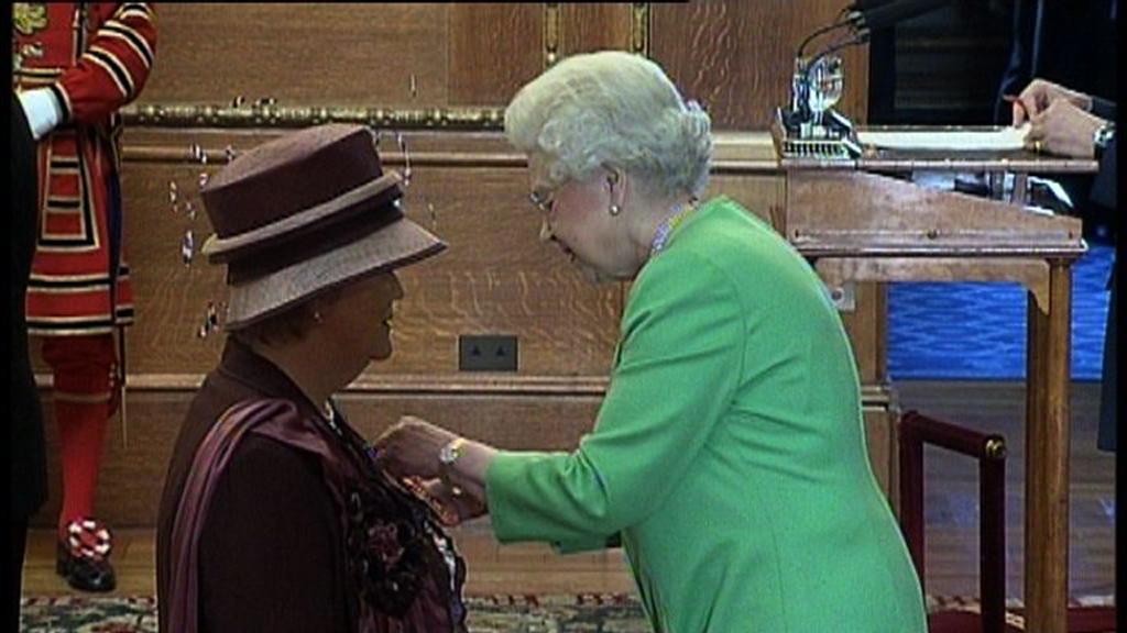 Queen Elizabeth giving Dorothy Purdew her OBE