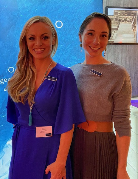 two woman at an event smiling at camera