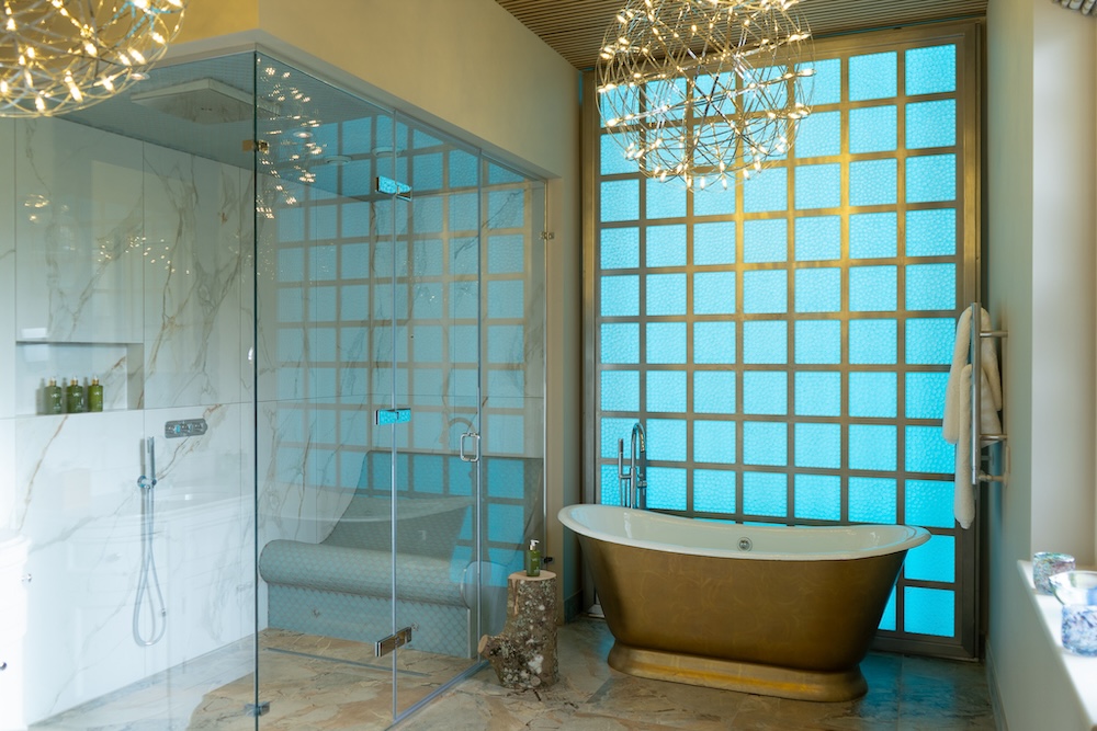 Hotel bathroom with aged bath and turquoise tiles