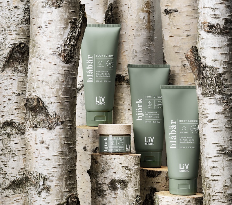 Spa products in sage green bottles against tree branches