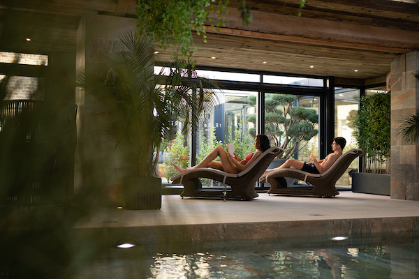 people relaxing in loungers by a spa swimming pool