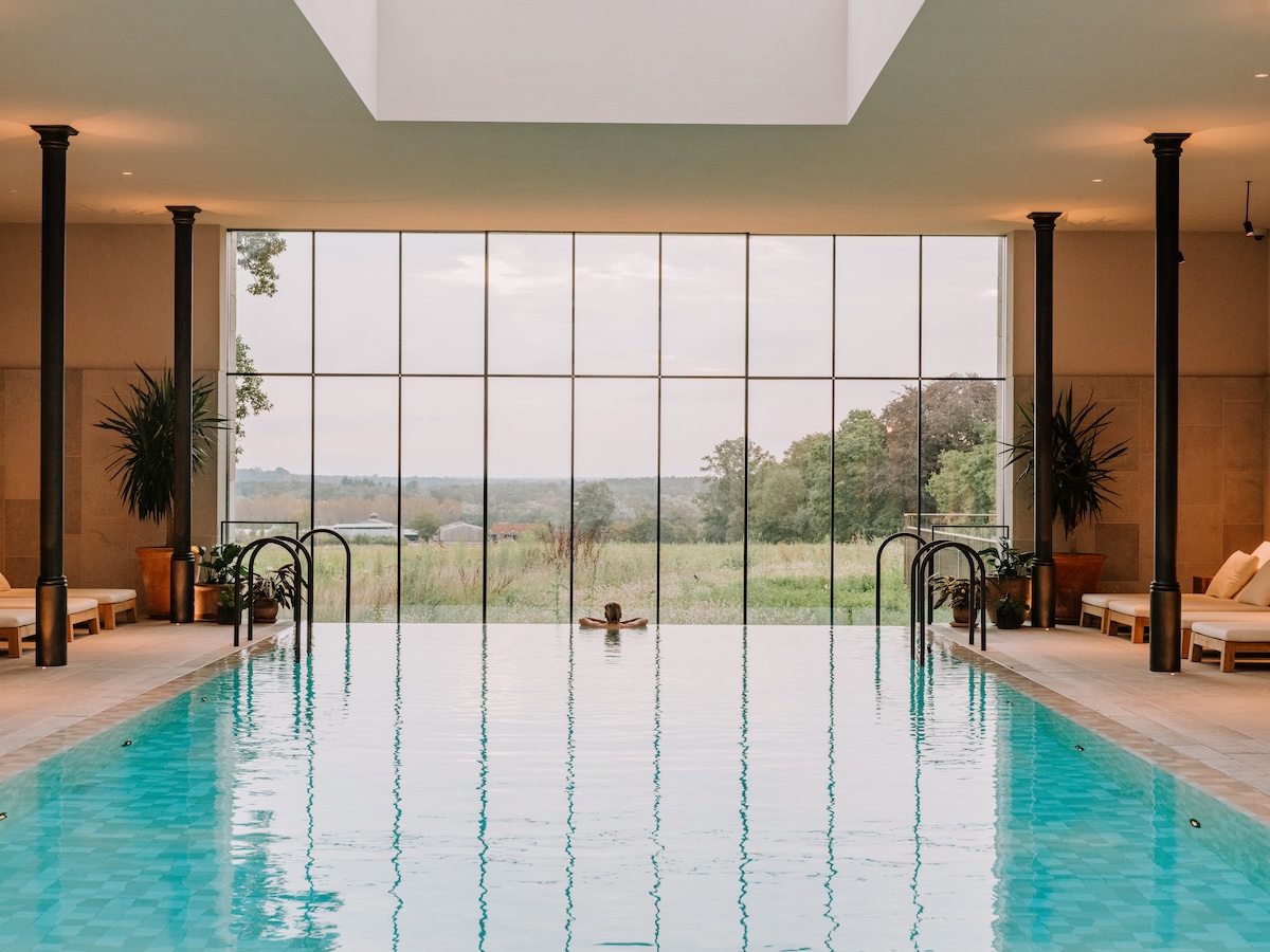a blue swimming pool overlooking english countryside