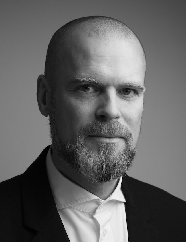 Black and white photo of man in suit with no hair