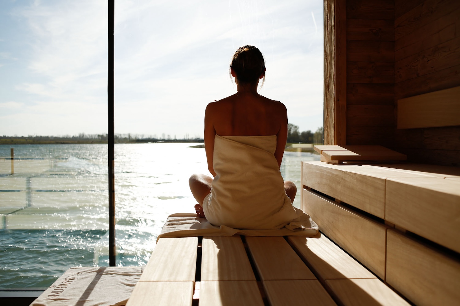 Woman in sauna looking out over water