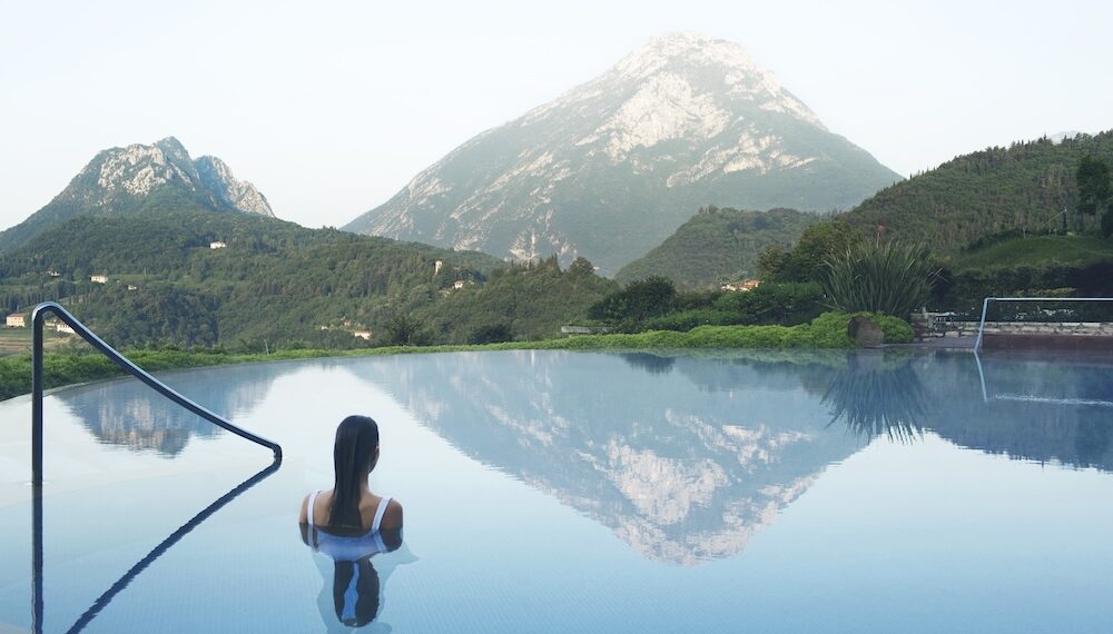 Woman in outdoor pool overlooking a mountain