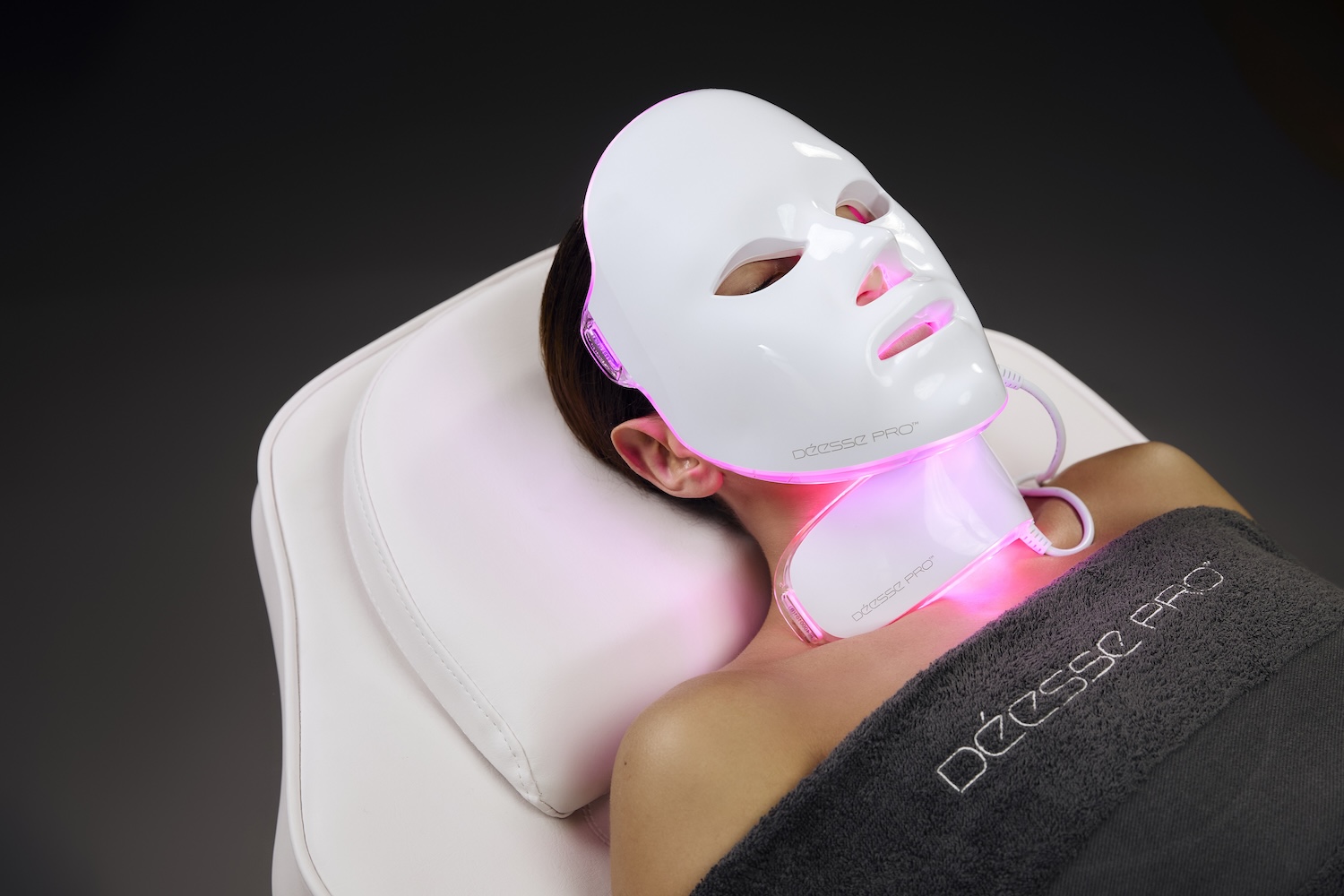 Woman laying on treatment bed wearing LED mask