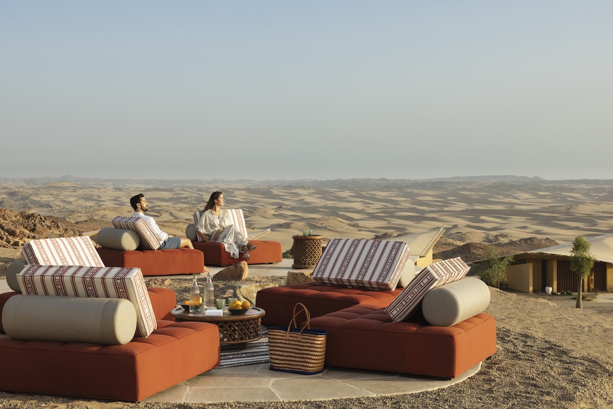 Couple sat on sofas in the saudi arabian dunes
