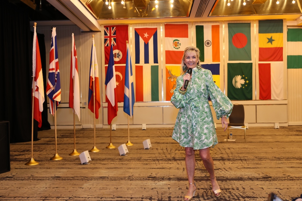 woman holding microphone in front of flags fro countries of the world
