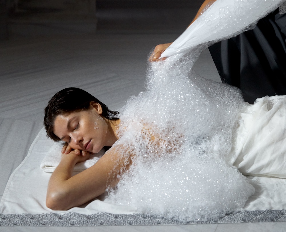 woman laying on floor covered in soapy bubbles