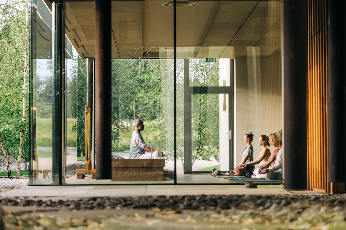 People meditating in a glass walled room