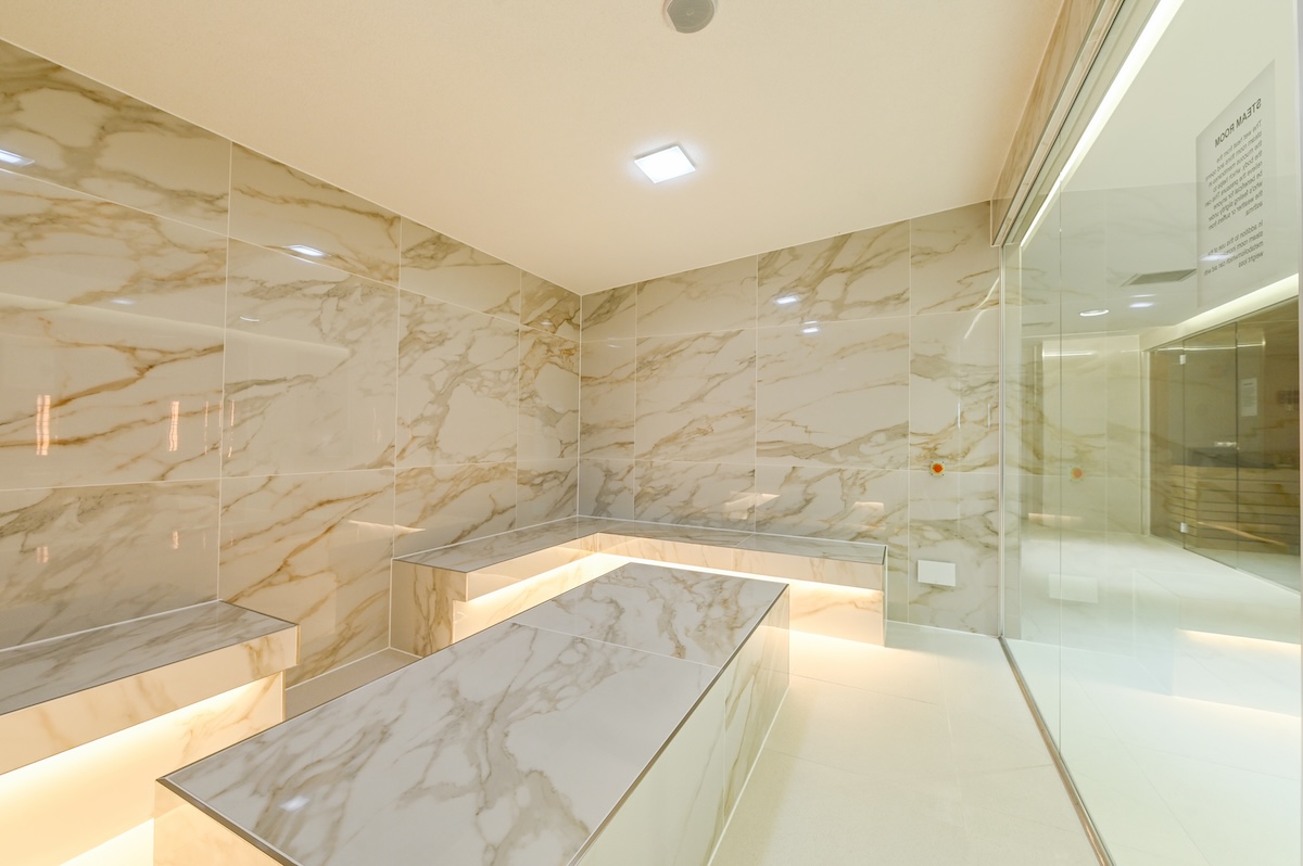 A steam room with white marble interior tiles