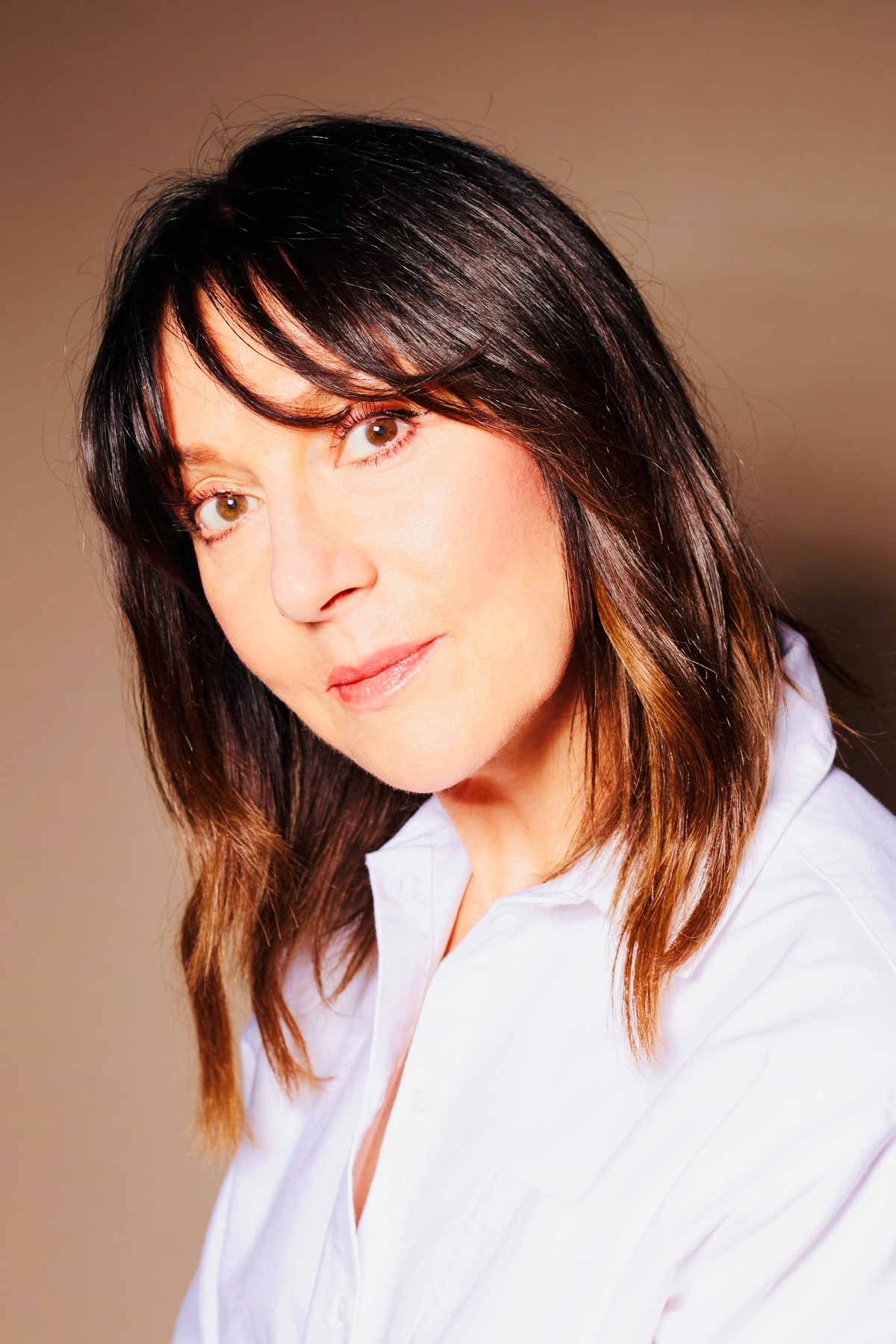 Headshot of woman with brown hair in white shirt