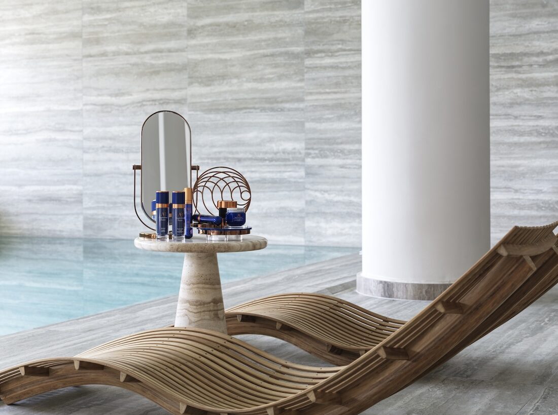 Spa products on a table next to pool and loungers