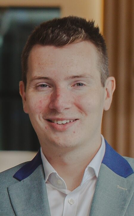 Headshot of man in grey jacket