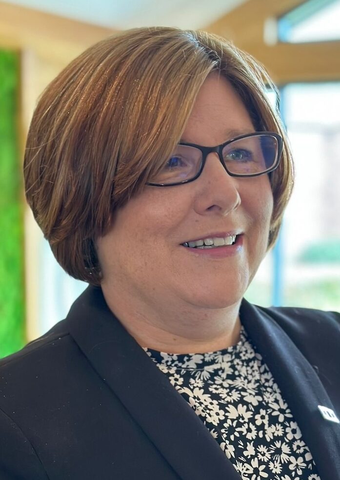 Headshot of a woman with short brown hair wearing a suit jacket