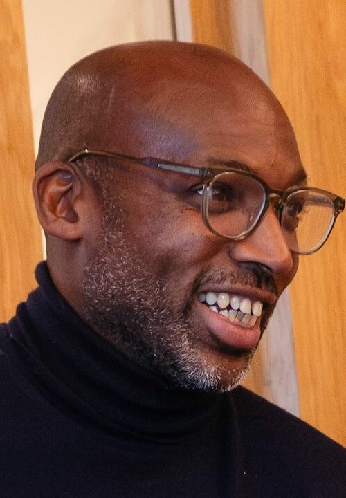 Smiling man wearing glasses an black polo neck