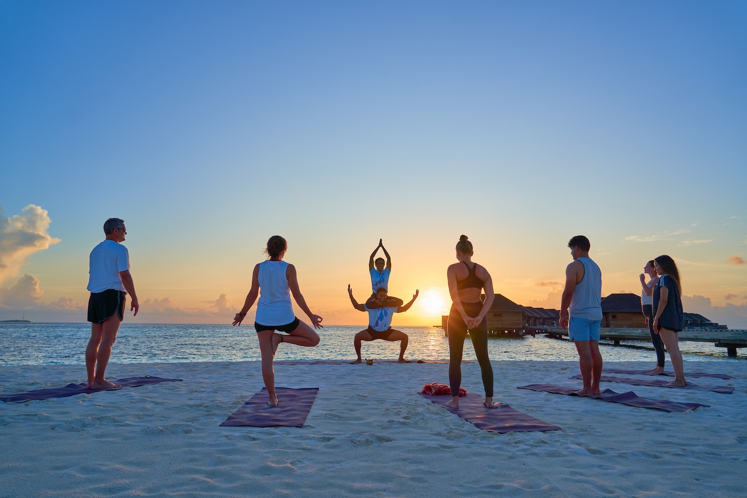 People doing yoga on a beach