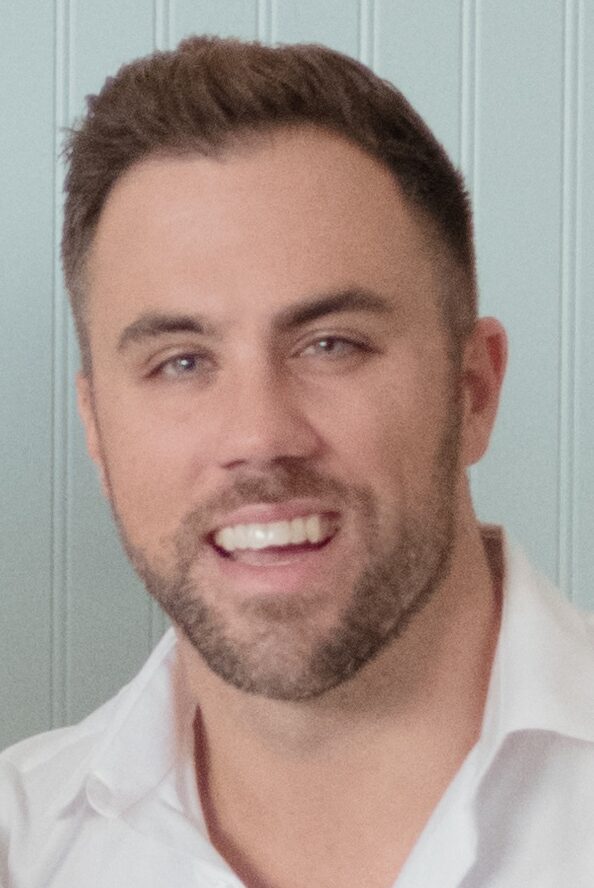 Smiling man with beard in white shirt