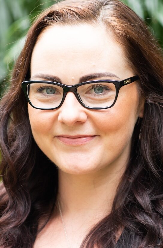 Smiling dark haired woman with glasses