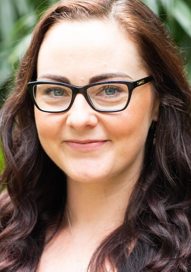 Smiling dark haired woman with glasses