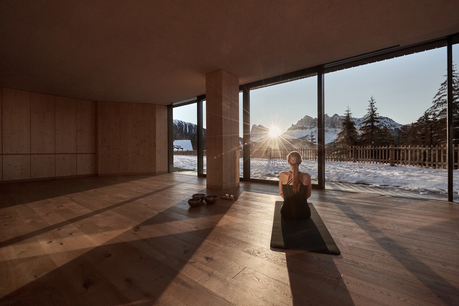 A wood floored yoga studio with a glass wall