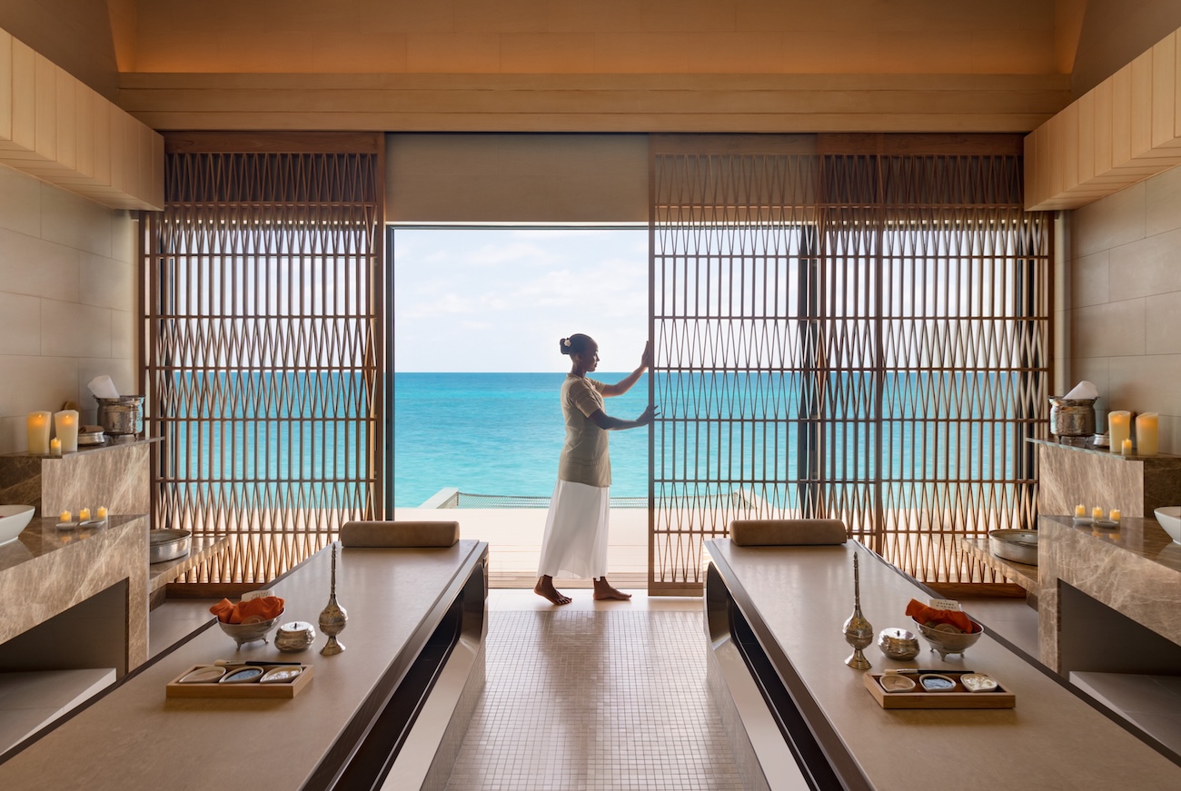 Woman opening sliding doors in an oceanfront villa