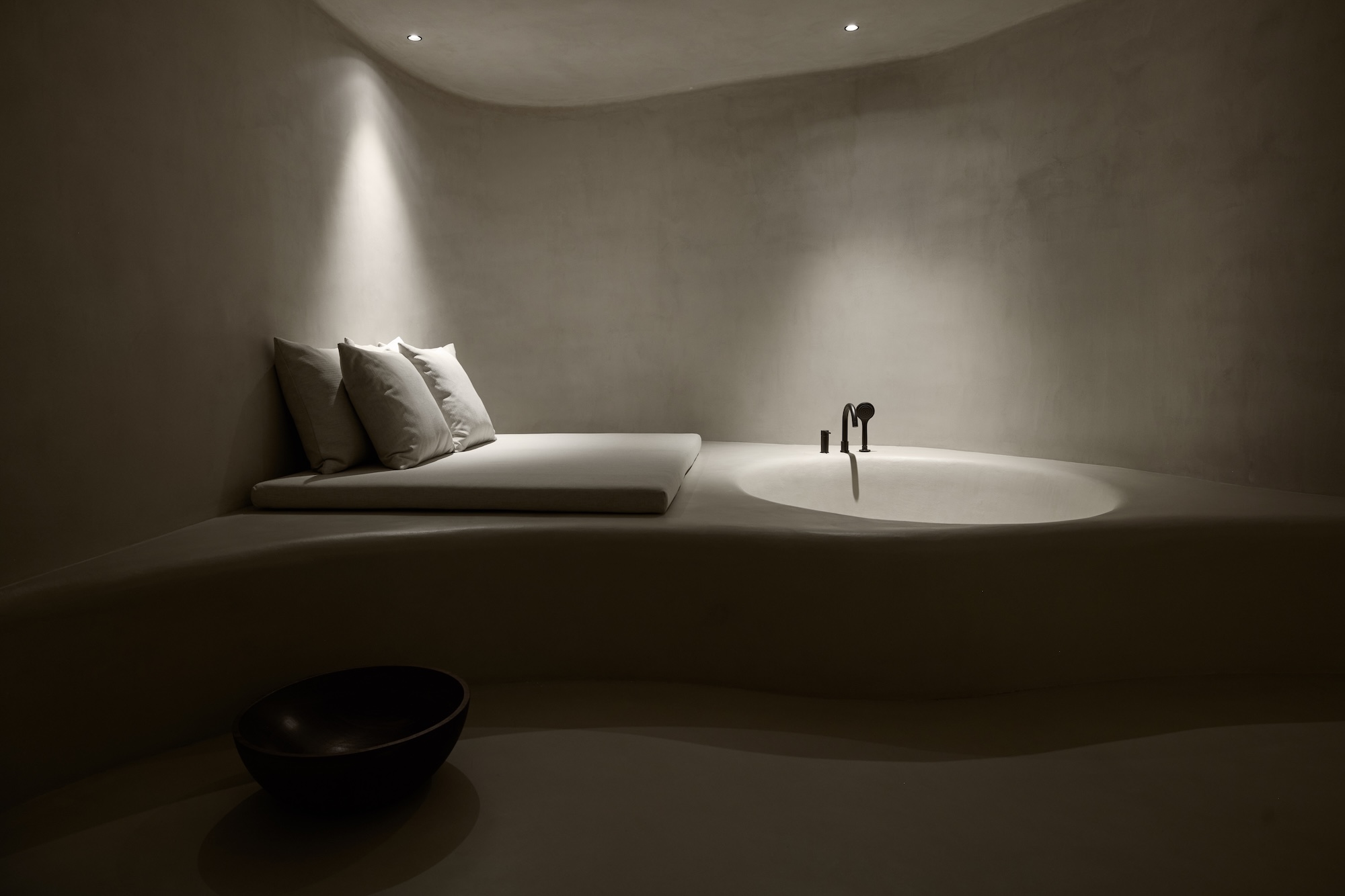 A stone sunken bath in a dimly lit room