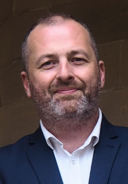 Man in suit leaning against a wall