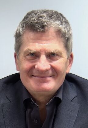 Close up headshot of man in grey suit