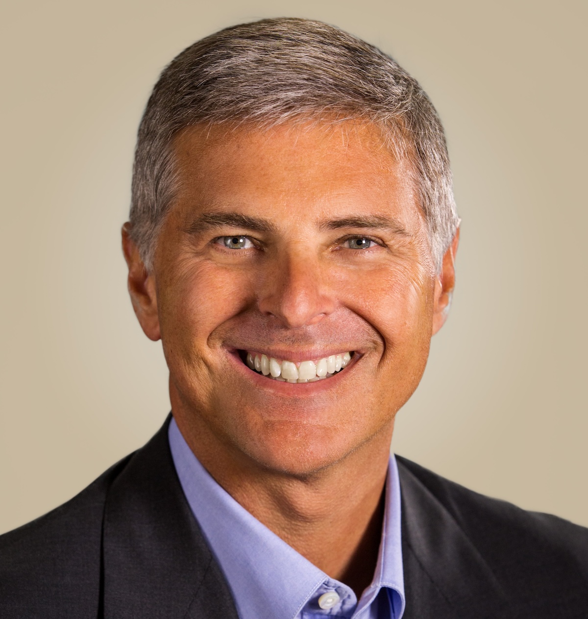 Smiling man in grey suit and purple shirt