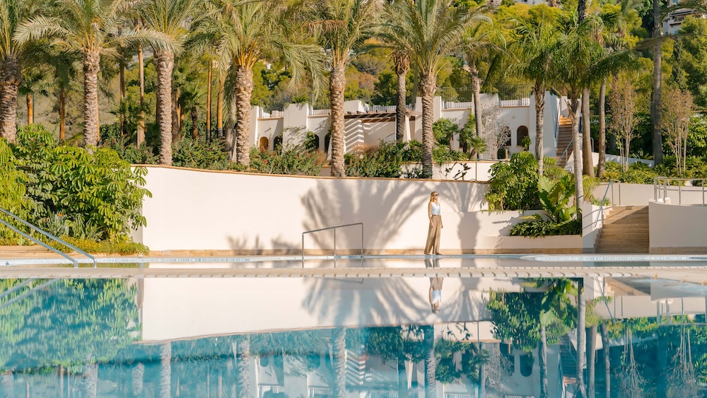 An outdoor swimming pool surrounded by lush greenery