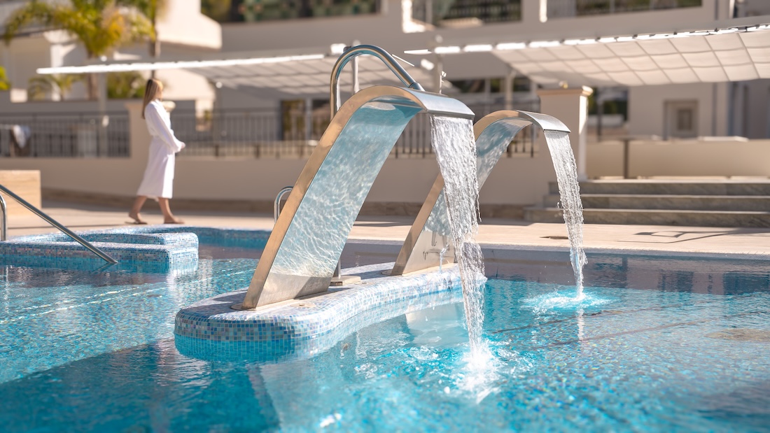 An outdoor pool with waterfall jets