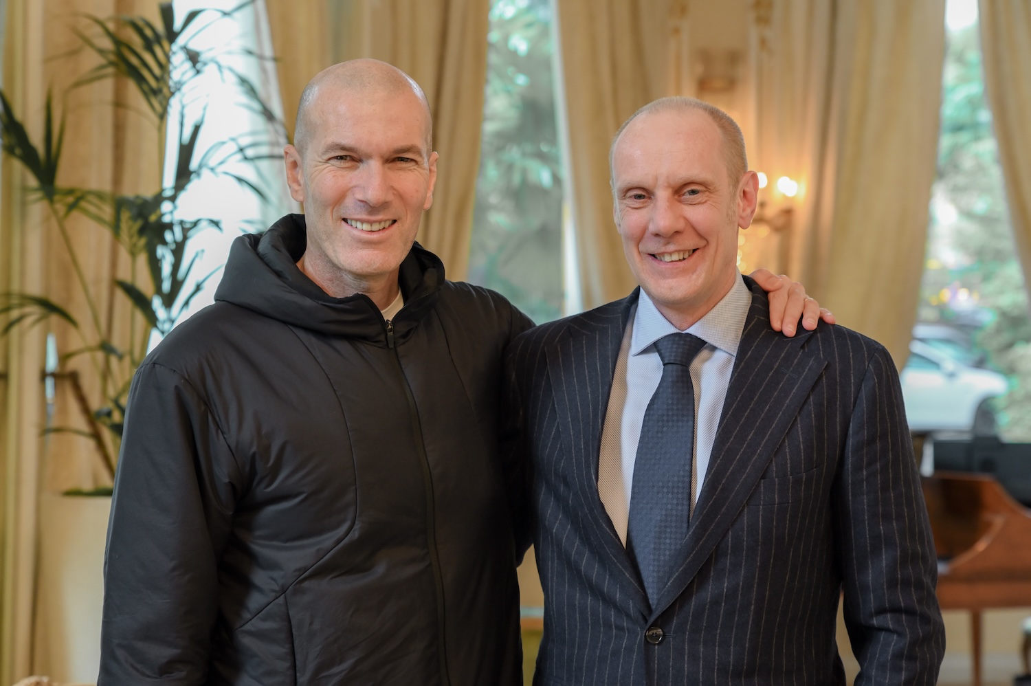 Two men smiling at the camera, one with arm on the other's shoulders