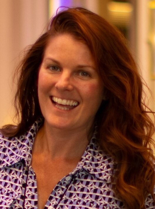 Smiling brown haired woman in long patterned dress