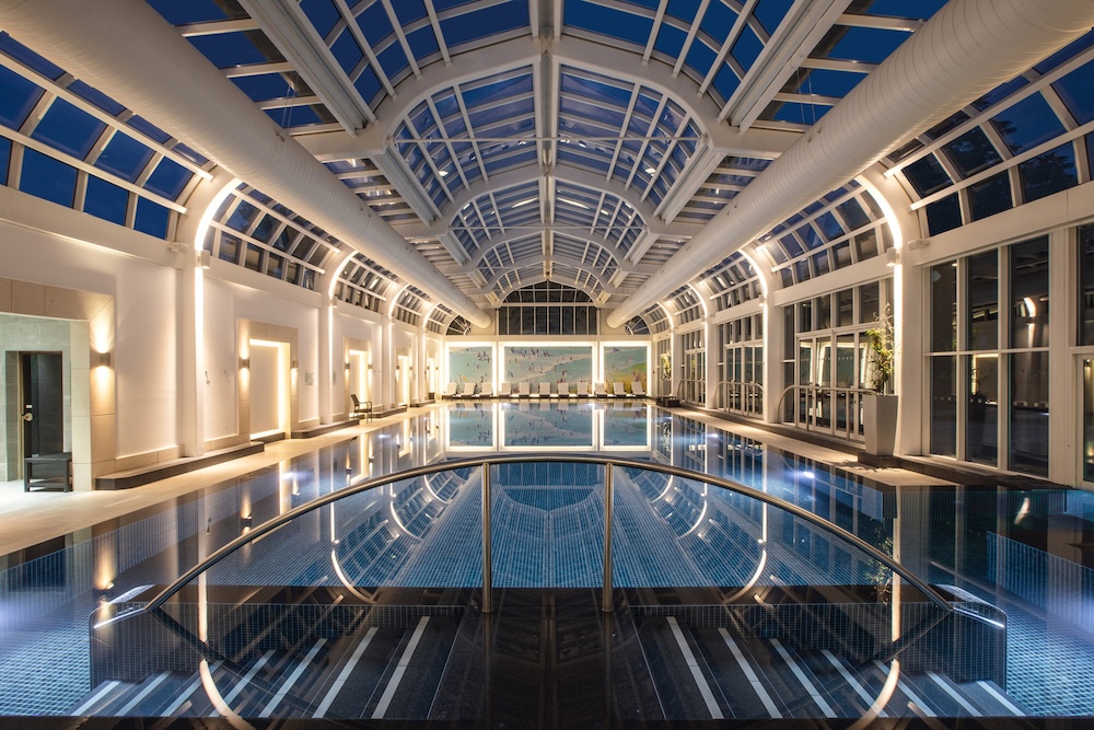 A swimming pool within a glass roofed conservatory