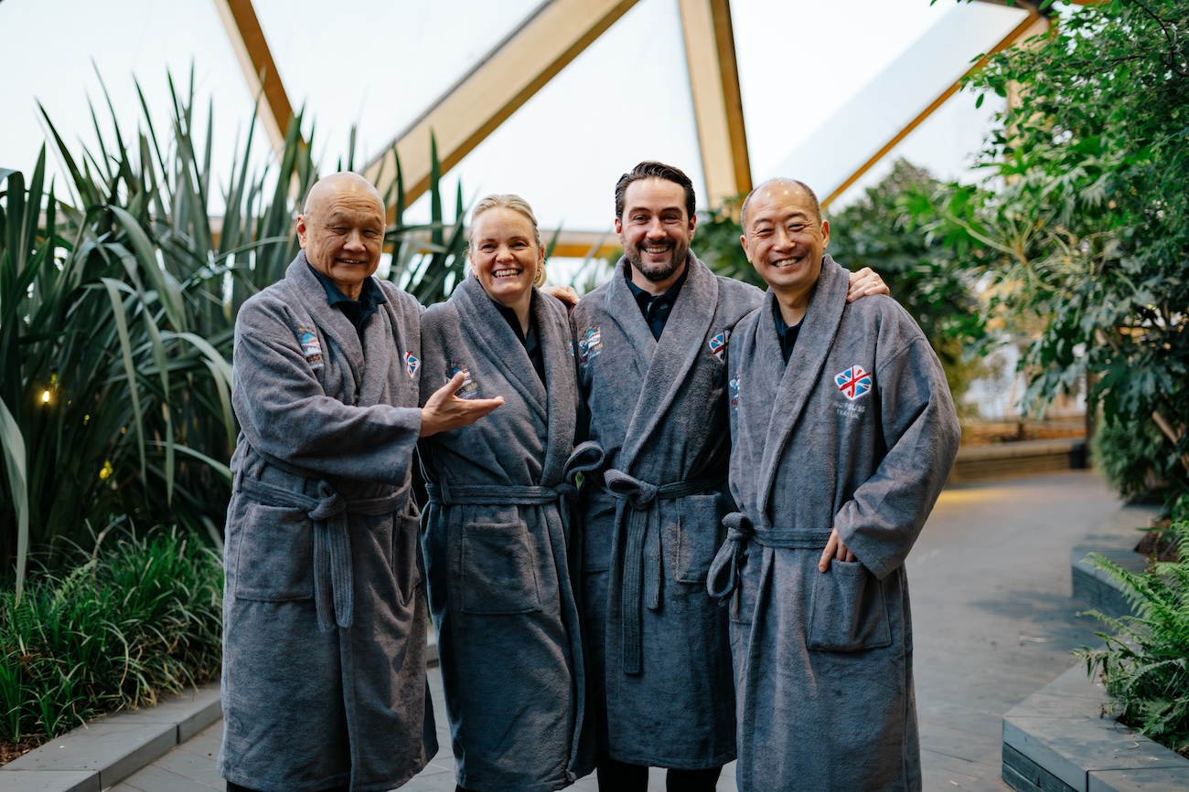 Four people in grey bathrobes