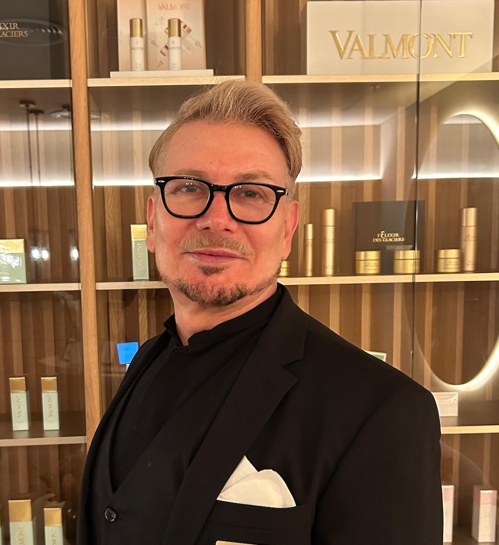 Man in black shirt and jacket wearing glasses