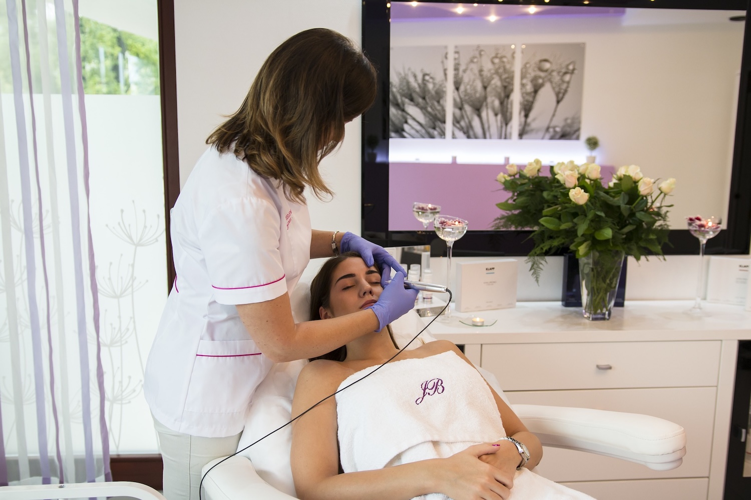 Therapist performing facial procedure on a guest
