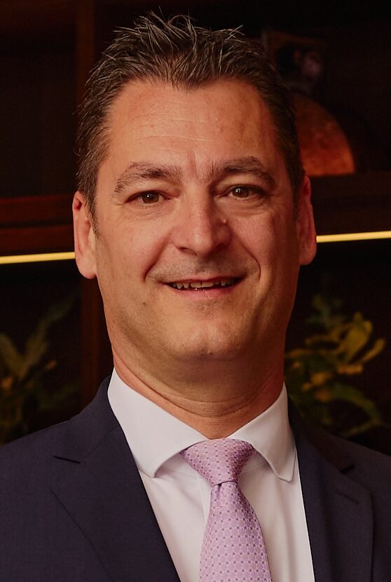 Smiling man wearing dark suit posing for headshot